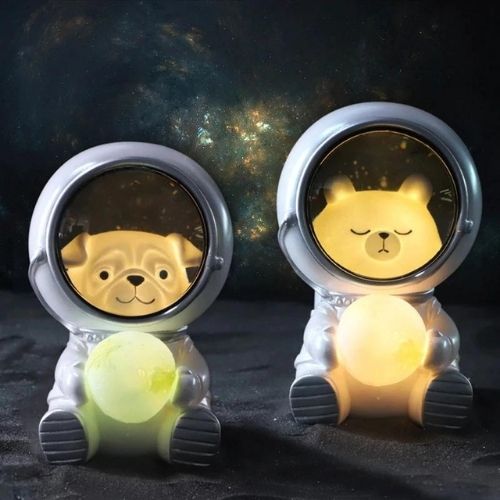 Two bear-shaped night lights in astronaut suits against a starry space background.