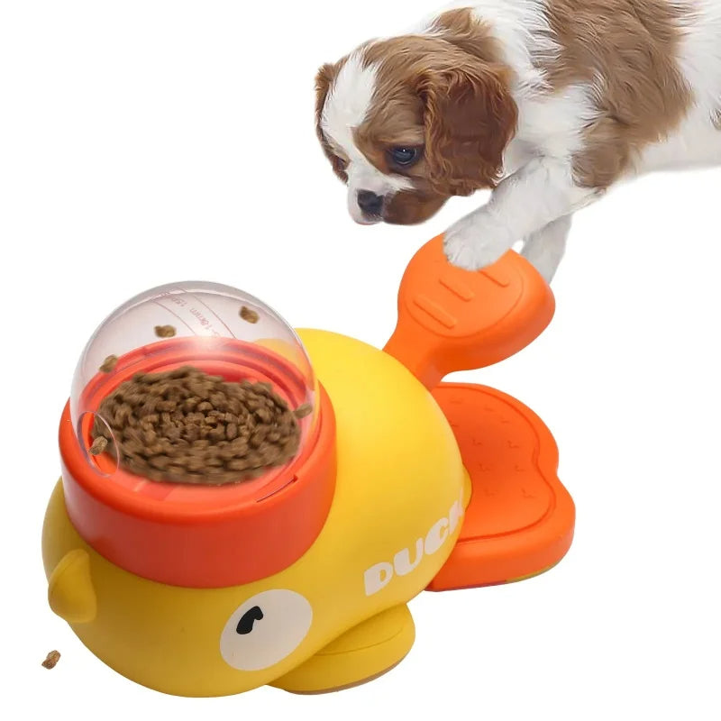 Yellow and orange duck-shaped pet toy with food dispenser, featuring a puppy interacting with it.