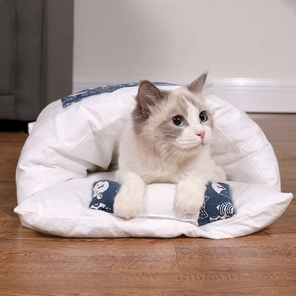 Cat lying on a white pet bed with blue patterns on a wooden floor.